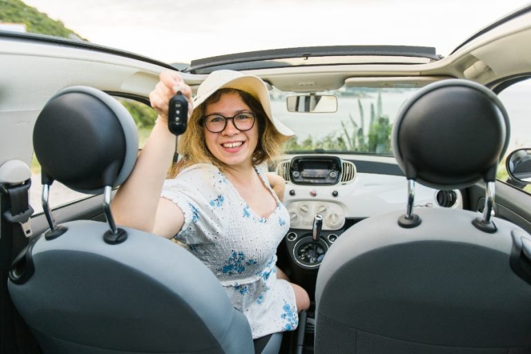 Entrepreneur inaugurant son agence de location de voitures avec un panneau et des véhicules prêts à louer