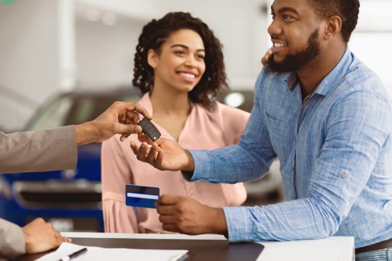 Un homme signe les papiers de son financement automobile après avoir obtenu un taux avantageux