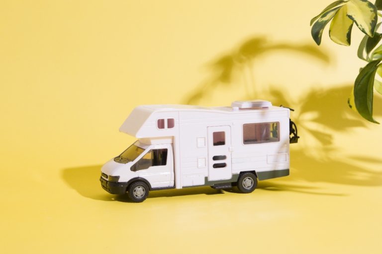 Voiture légère prête à être tractée derrière un camping‑car sur aire de repos