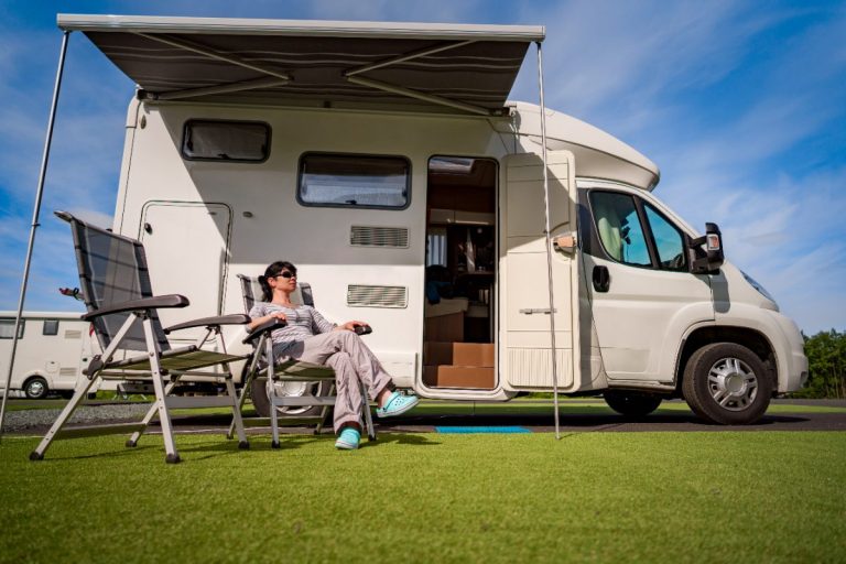 Une fille qui se repose devant un camping-car tout neuf