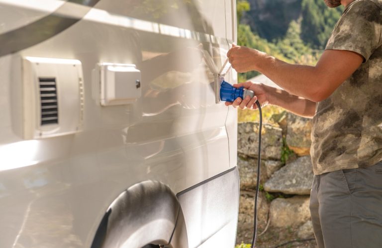Un homme réalise un raccordement électrique pour un camping-car