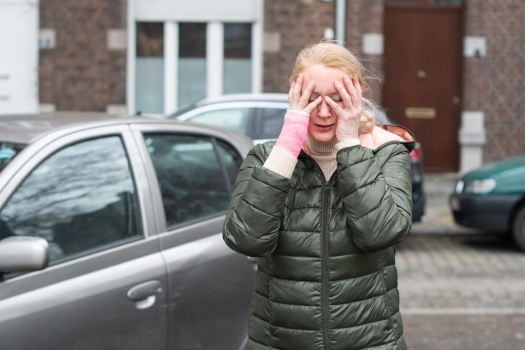 Une femme triste près de sa voiture