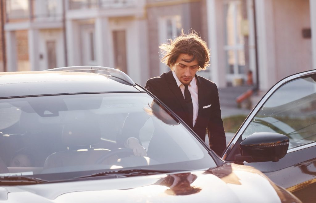Un homme qui entre dans sa voiture