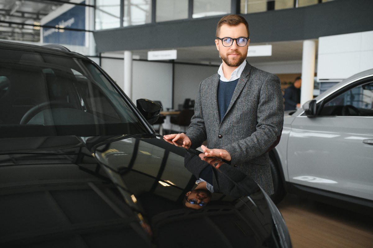 Un homme portant une lunette et travaille dans une concession automobile