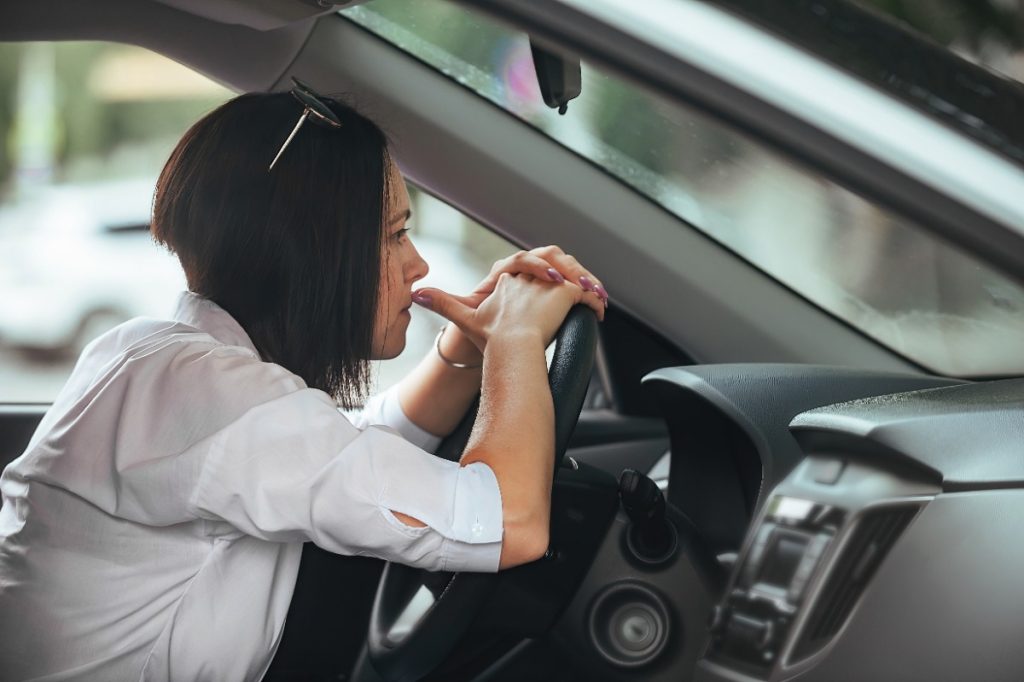 Une femme bouleversée conduisant une voiture