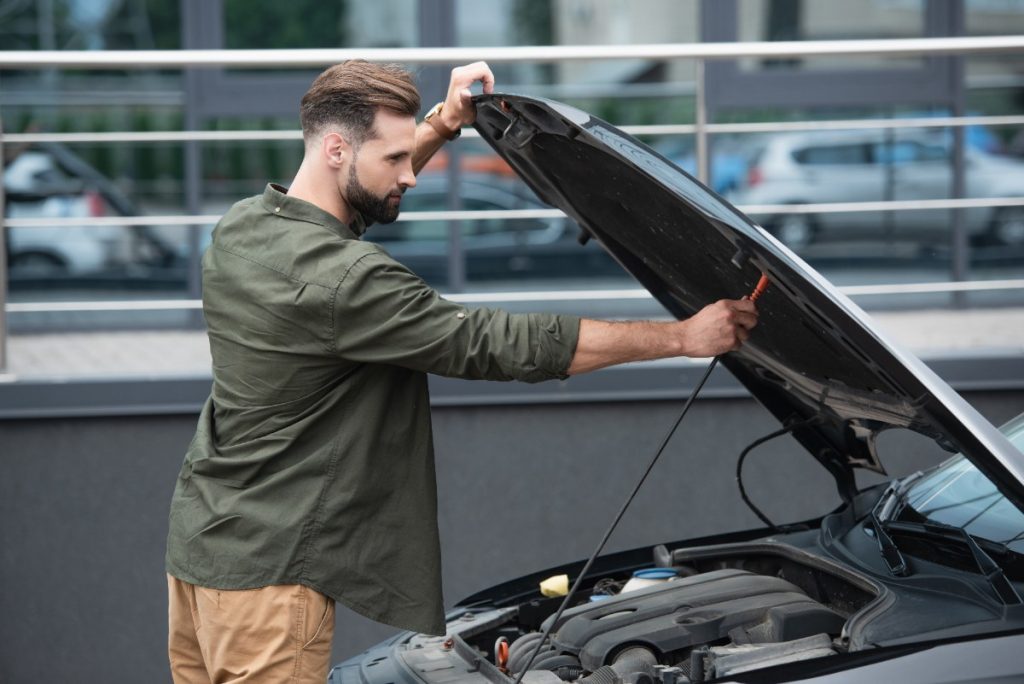 Un homme ouvrant le capot de la voiture