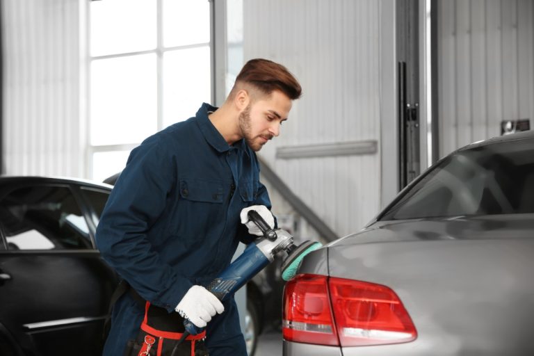 Un homme polissant la carrosserie d'une voiture