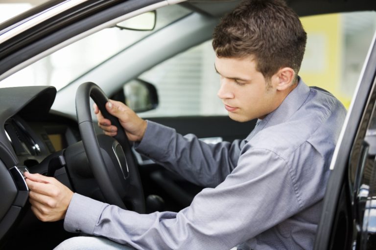 Un jeune homme démarrant la voiture