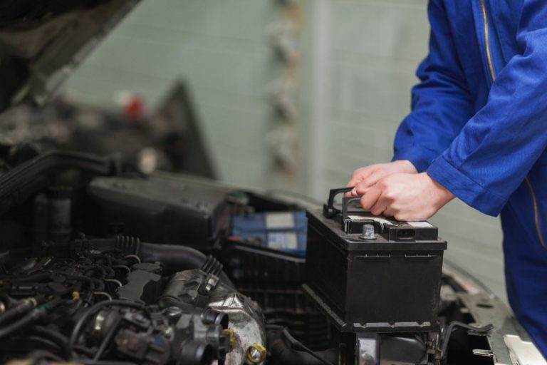 Un mécanicien changeant la batterie d'une voiture