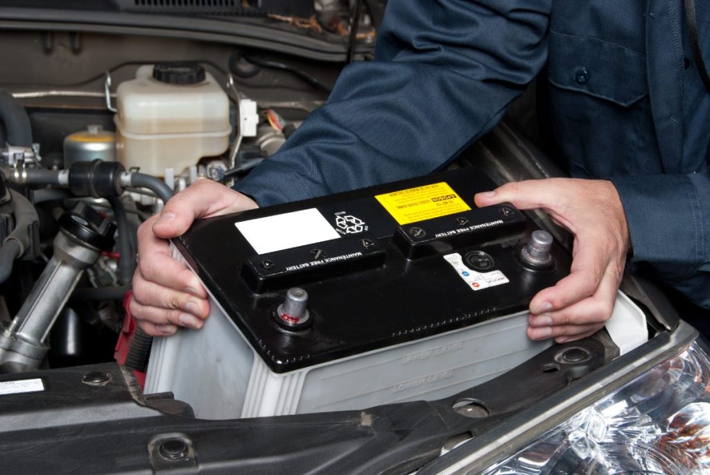 Un mécanicien remplaçant la batterie d'une voiture