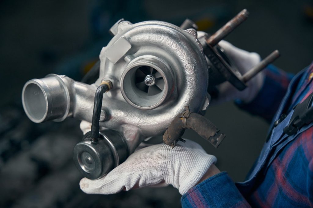 Un mécanicien tenant un turbocompresseur neuf