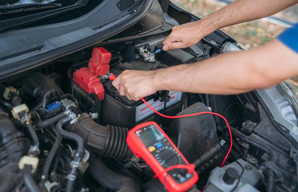 Un mécanicien qui teste la batterie d'une voiture