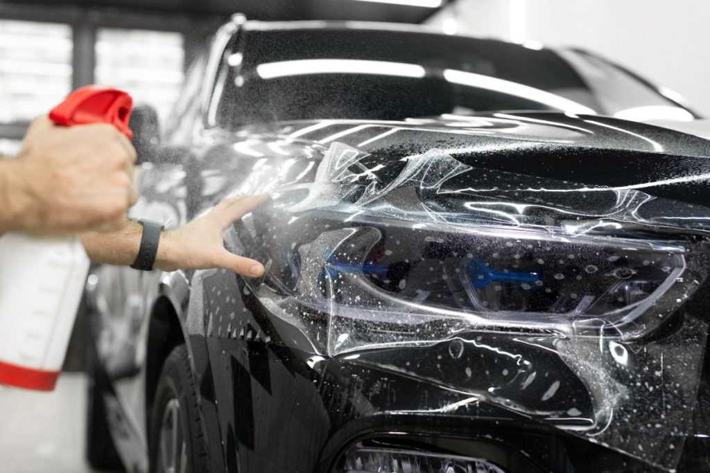 Un travailleur appliquant du film protecteur pour la voiture